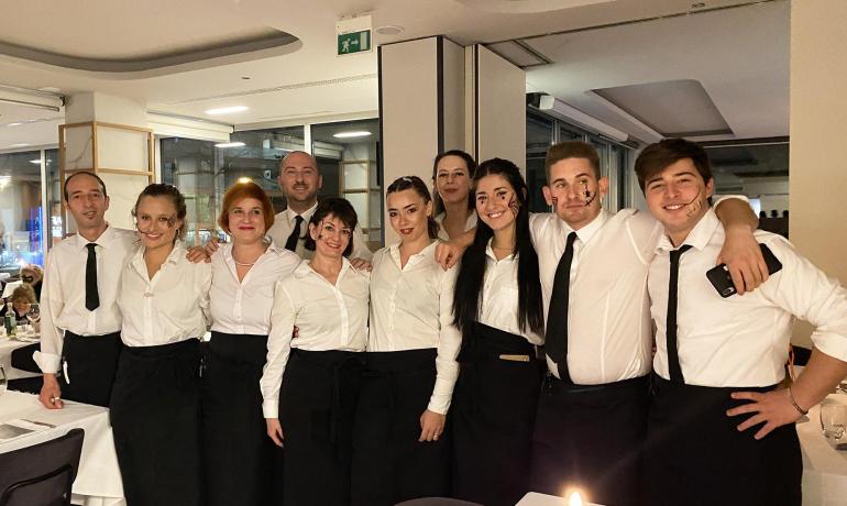 Group of smiling waiters in a restaurant.